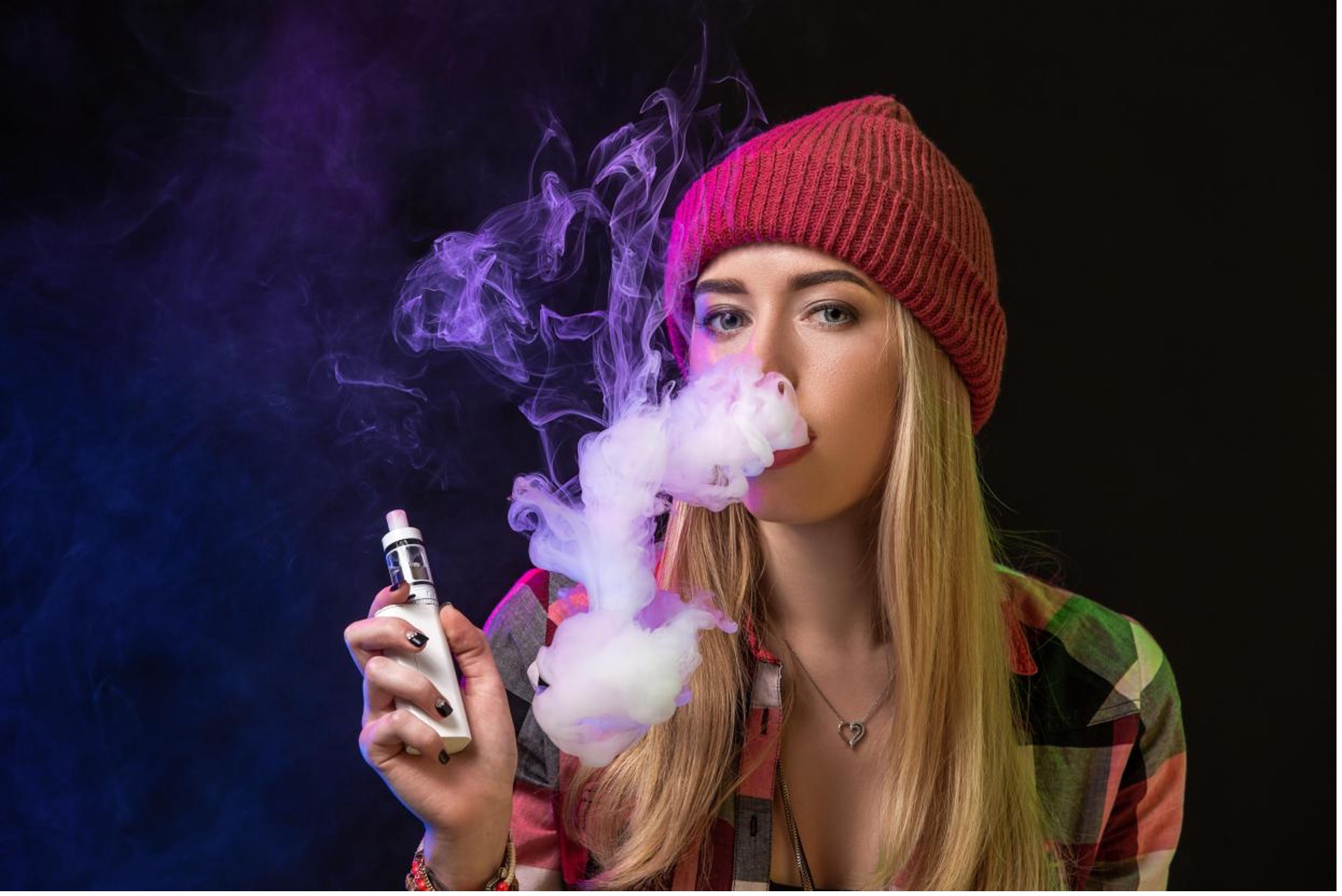A person wearing a hat and holding a vape
